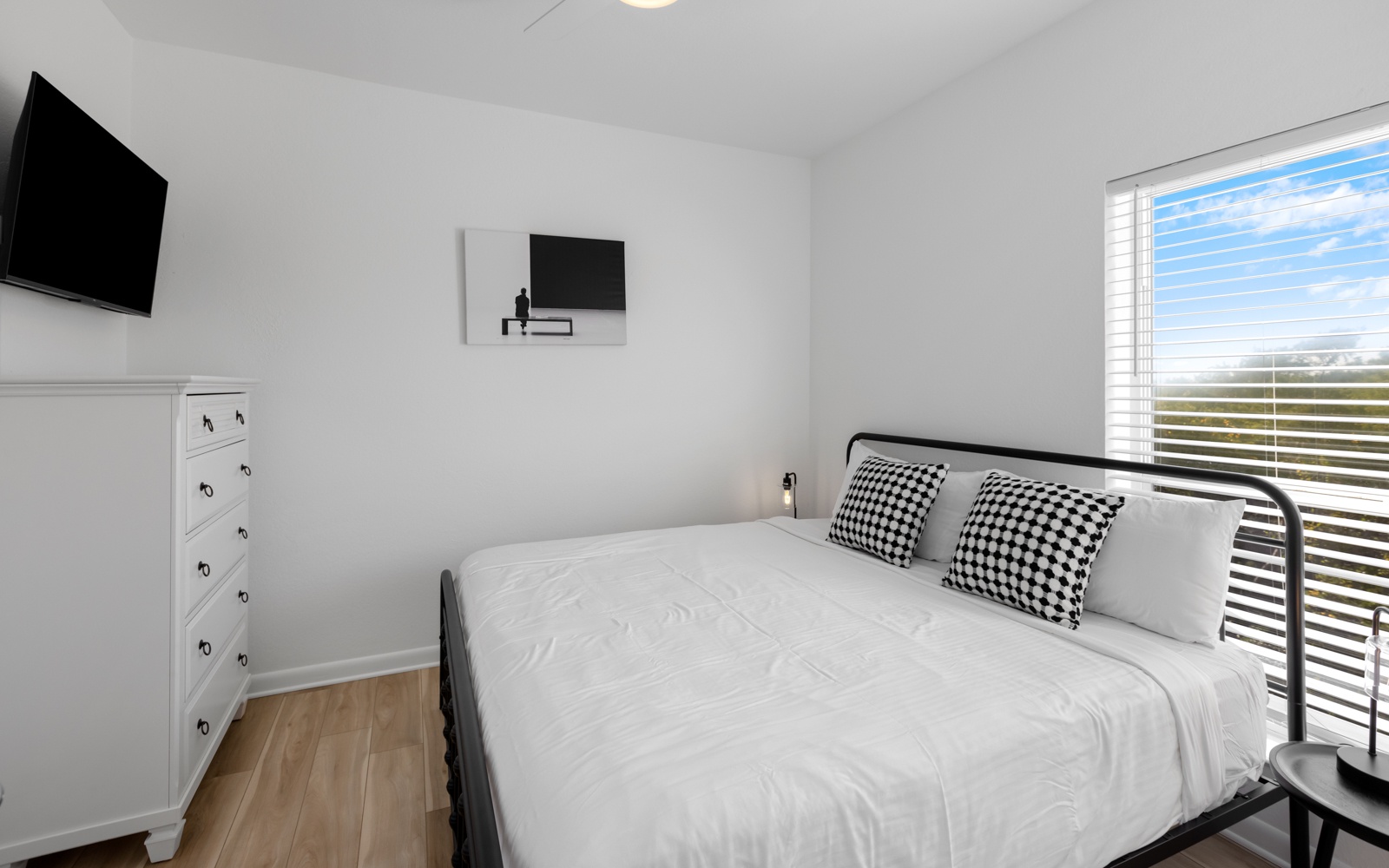 Your bright bedroom features crisp white linens and natural light streaming through the window, creating a serene space to rest.