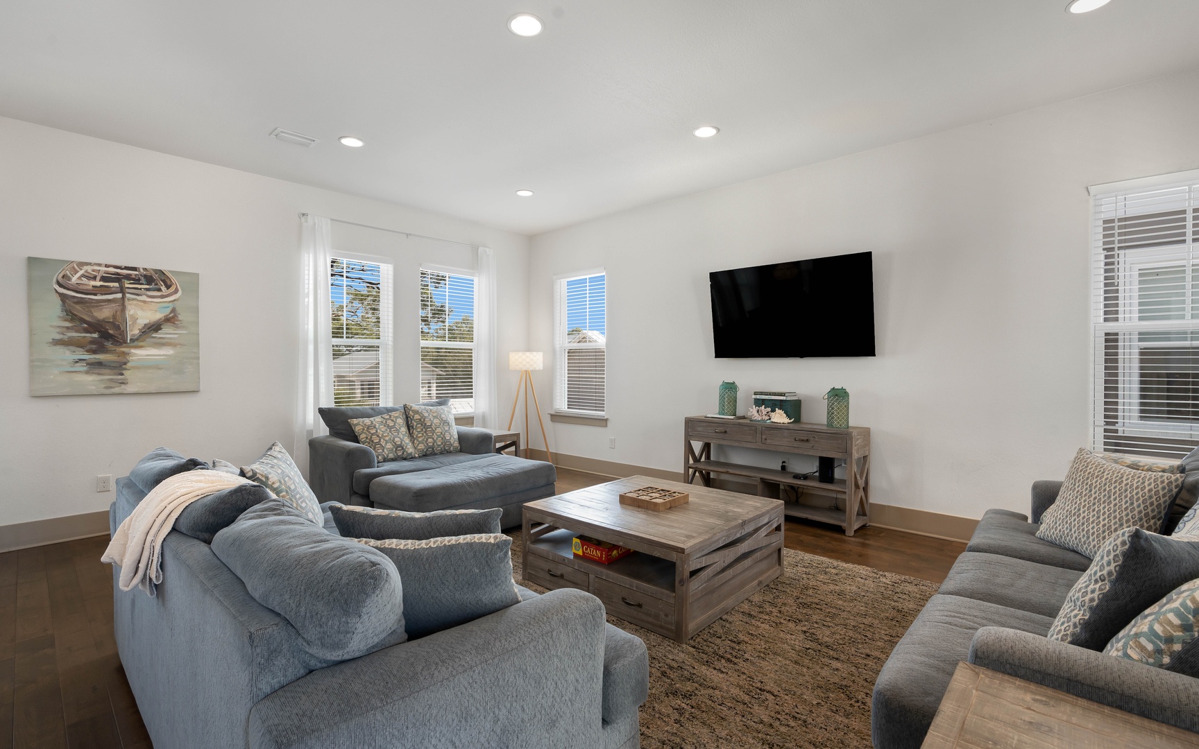 Sink into plush sofas while watching your favorite shows on the wall-mounted TV in this bright, coastal-inspired living space.