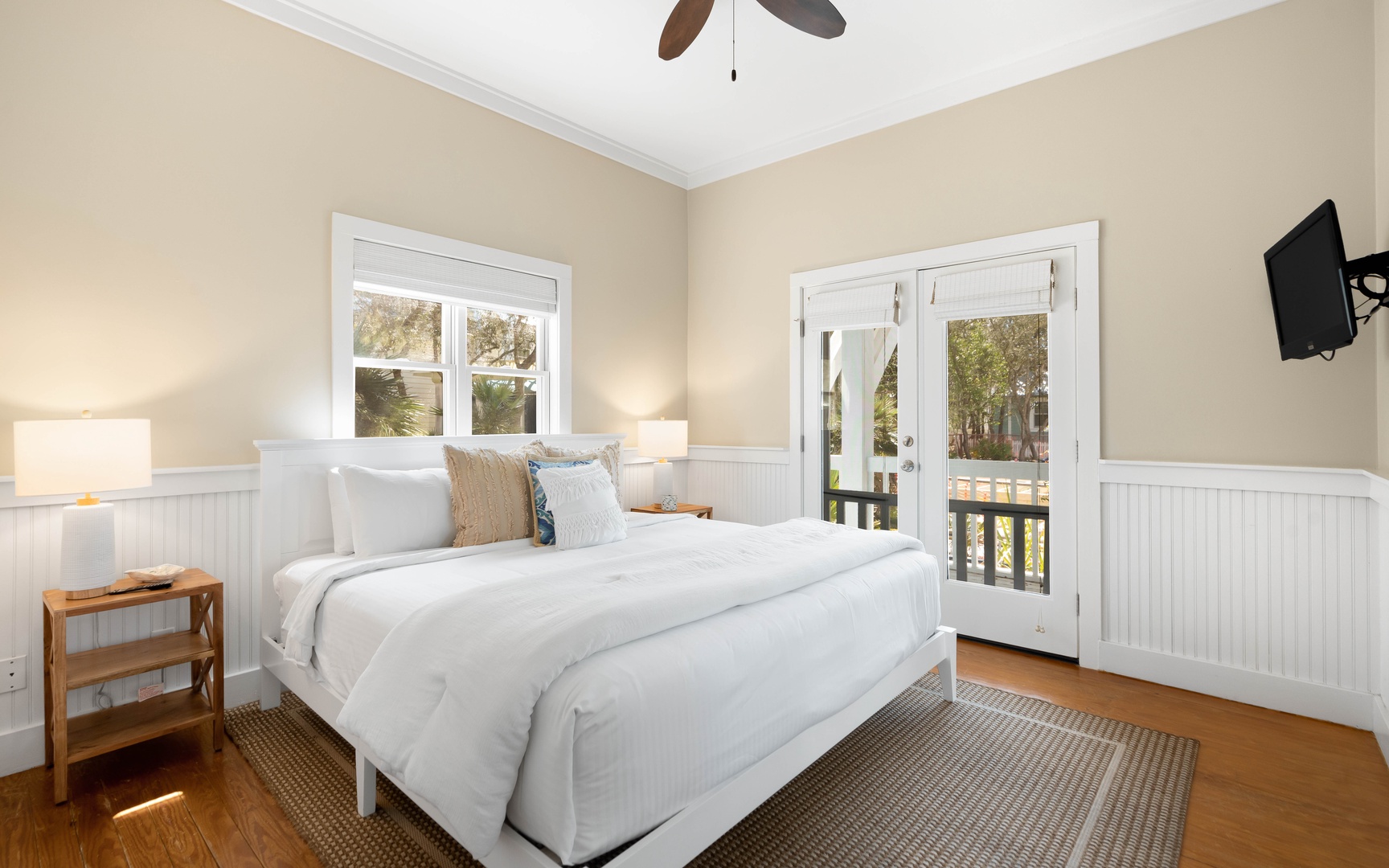 Your peaceful bedroom retreat features crisp linens, warm coastal charm, and French doors opening to your private balcony sanctuary.