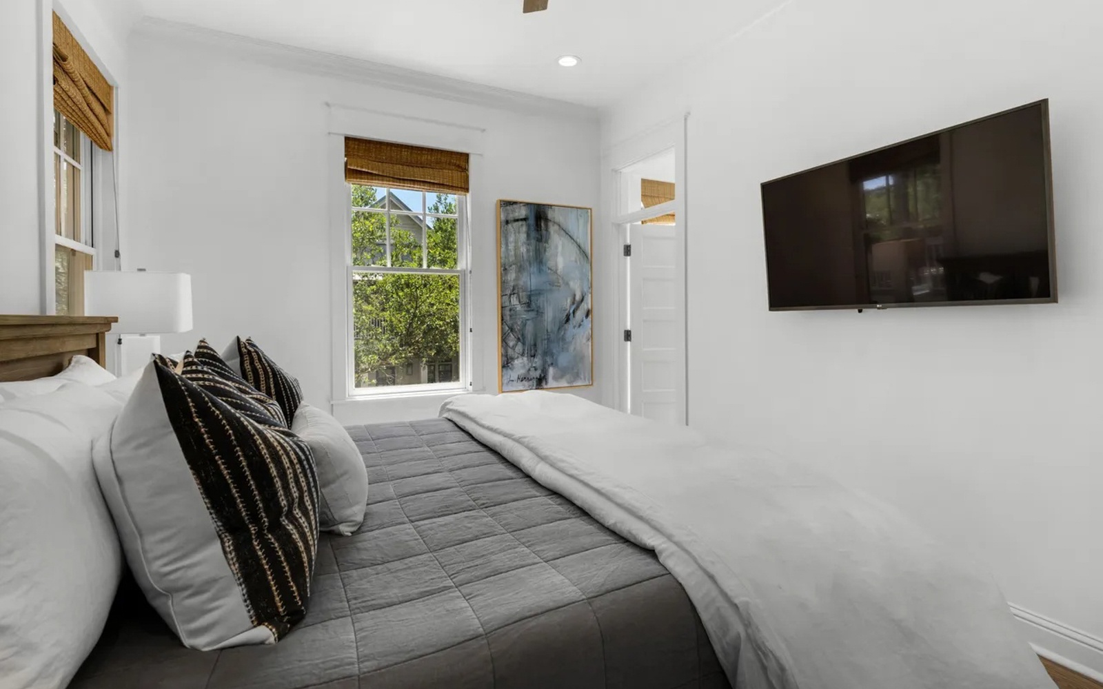 Unwind in your serene bedroom sanctuary with crisp linens, natural light streaming through bamboo shades, and modern amenities for perfect relaxation.