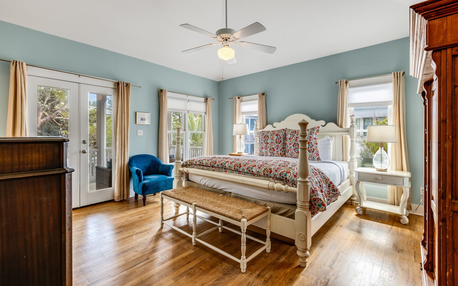 Unwind in this peaceful bedroom featuring soothing blue walls, gleaming hardwood floors, and French doors opening to your private balcony.
