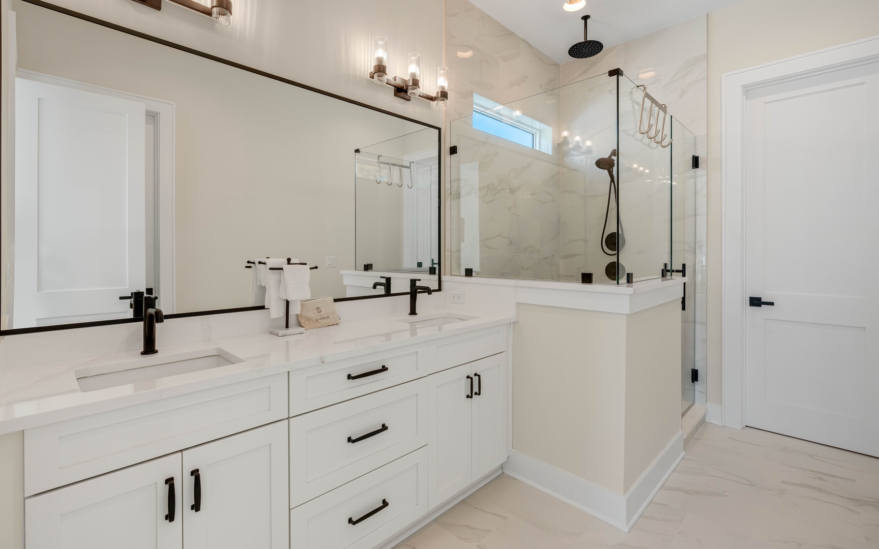 Indulge in your private spa-like retreat with elegant marble finishes, rainfall shower, and luxurious dual vanities for your daily pampering.