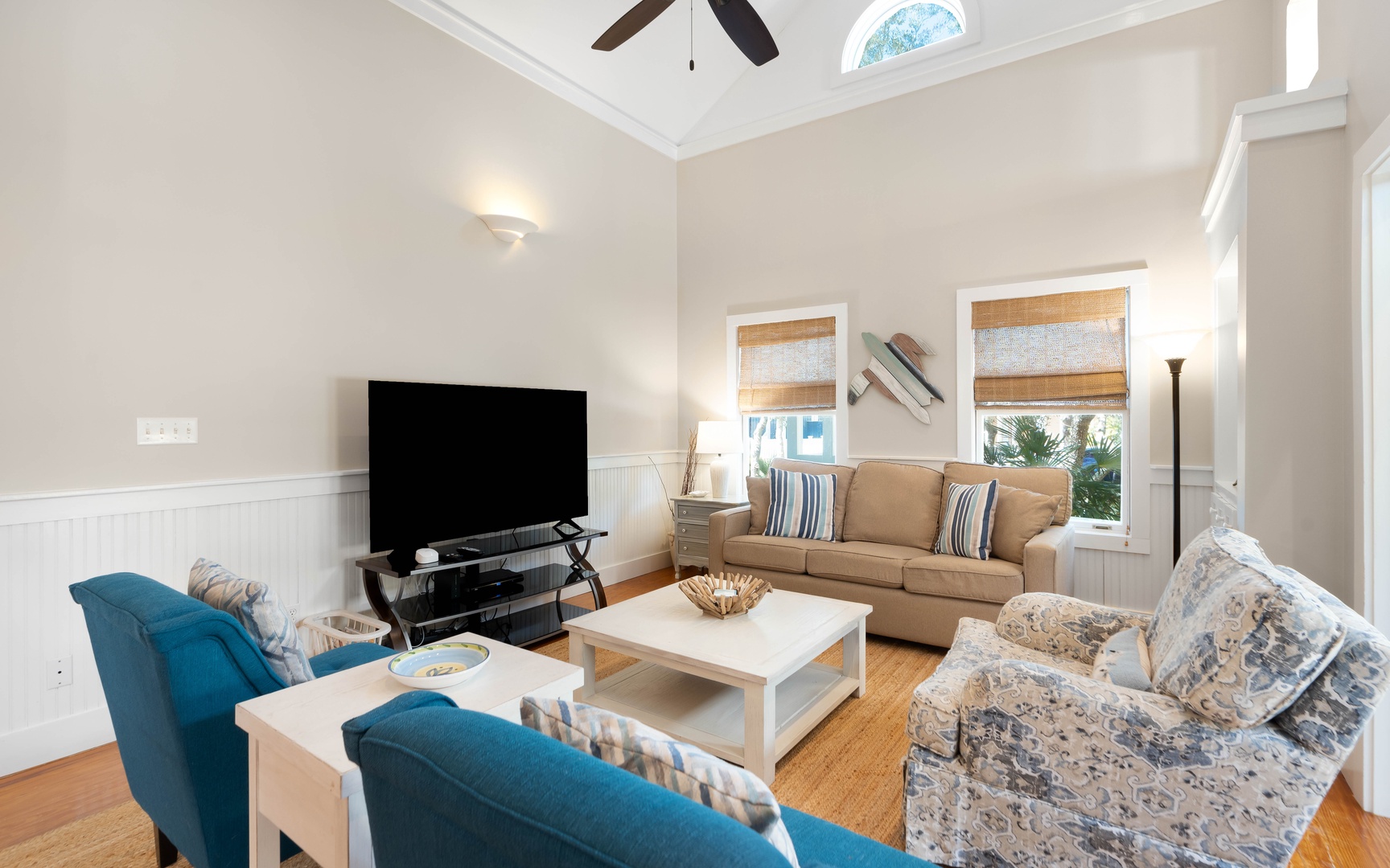 Sink into comfort in this bright living room with cozy seating, vaulted ceilings, and natural light streaming through bamboo shades.