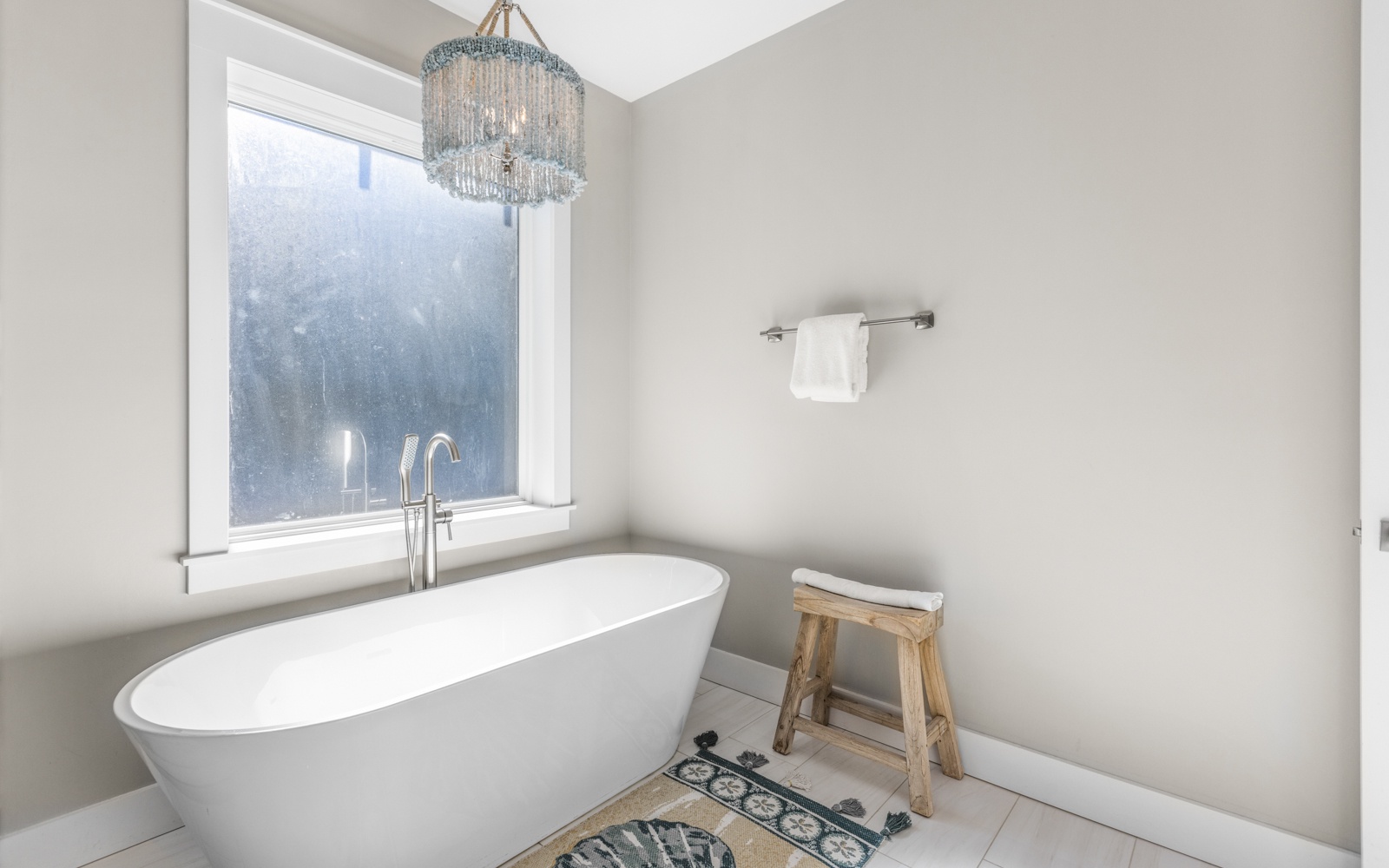 Slip into your private spa sanctuary where the elegant freestanding tub awaits beneath a stunning crystal chandelier, perfect for unwinding after your adventures.