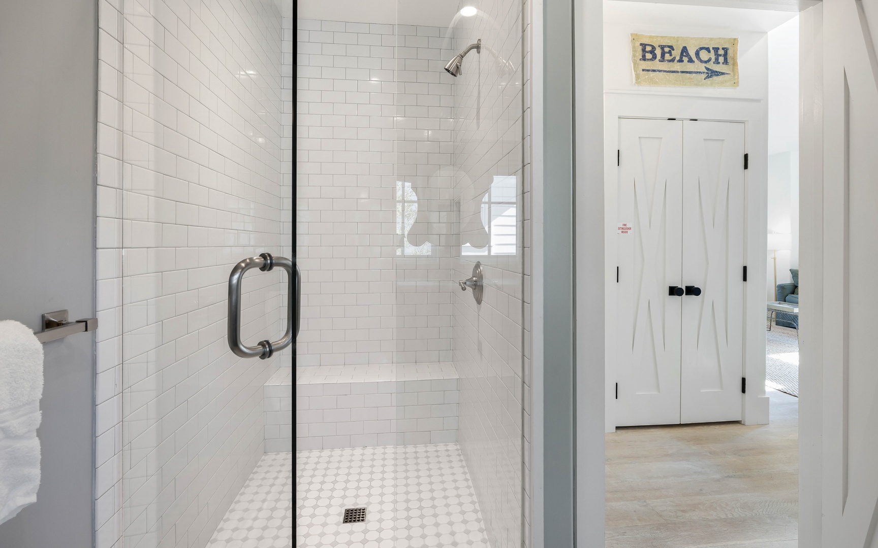 Step into your pristine glass-enclosed shower with classic subway tiles and rainfall showerhead for refreshing coastal mornings.