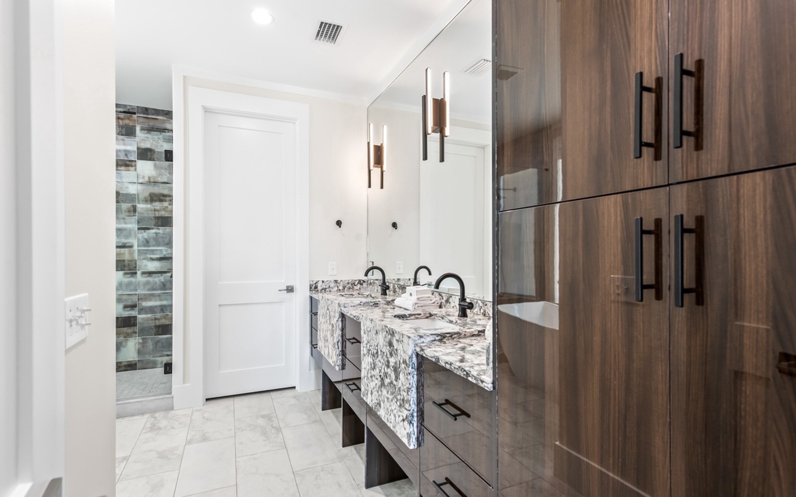 Your luxurious bathroom features stunning marble countertops, modern pendant lighting, and elegant wood cabinetry for a spa-like retreat.