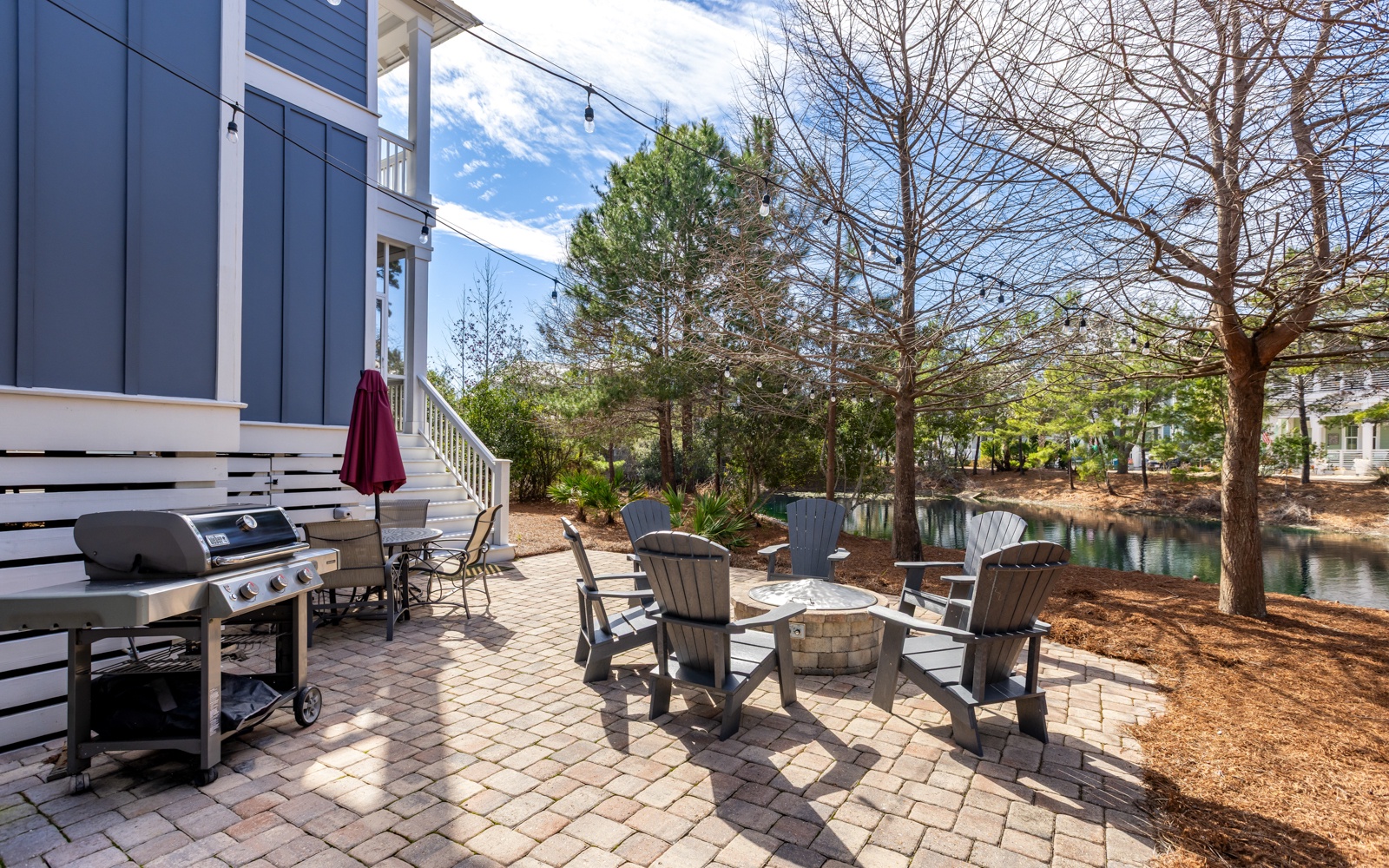 Your lakefront patio awaits with Adirondack chairs around a fire pit and BBQ grill for perfect evenings by the water.