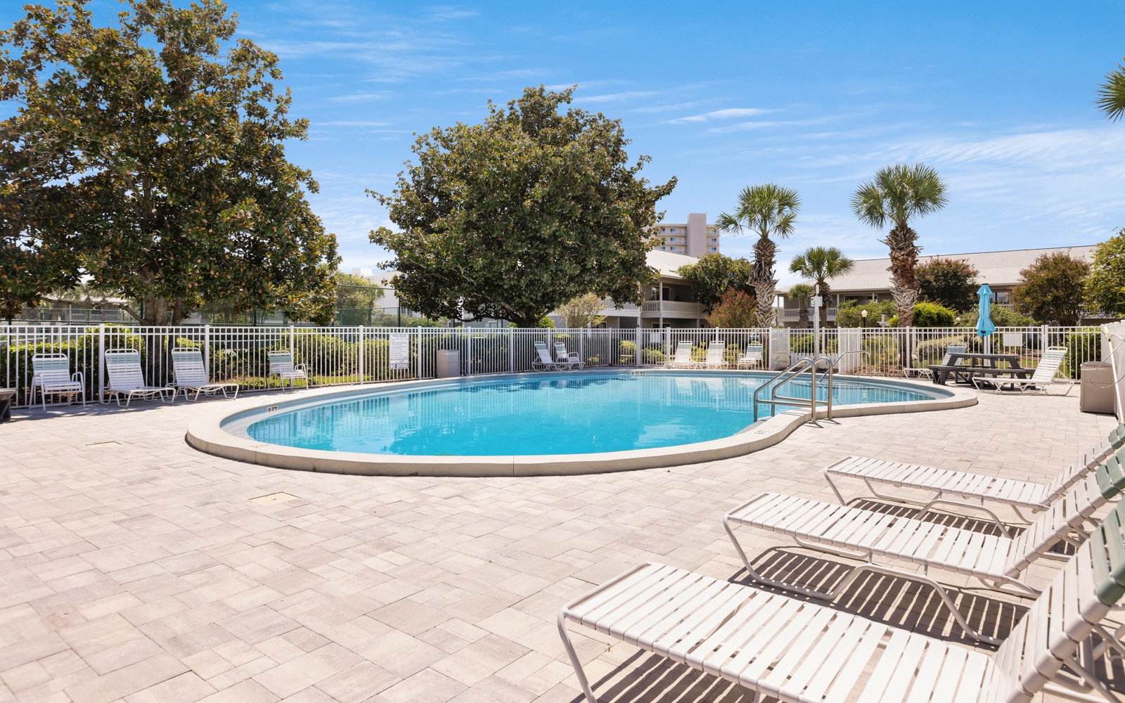 Take a refreshing dip in your private oval pool, surrounded by comfortable loungers and tropical palms for the perfect sunny getaway.