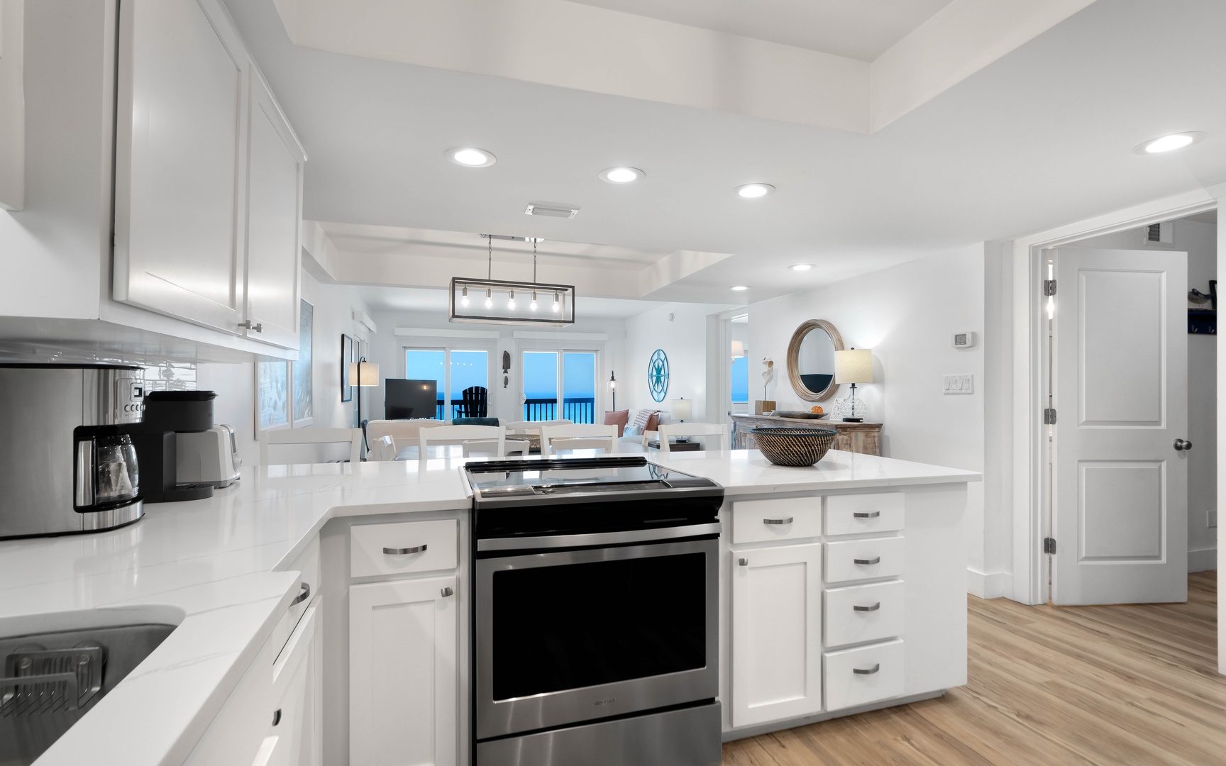 Your modern kitchen features bright white cabinetry, gleaming quartz countertops, and stainless steel appliances perfect for preparing meals during your stay.