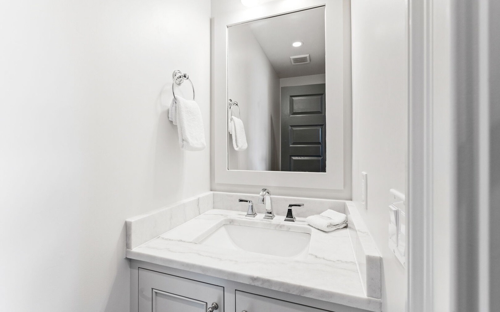 Step into your pristine bathroom featuring elegant marble countertops, fresh towels, and modern fixtures for your ultimate comfort.