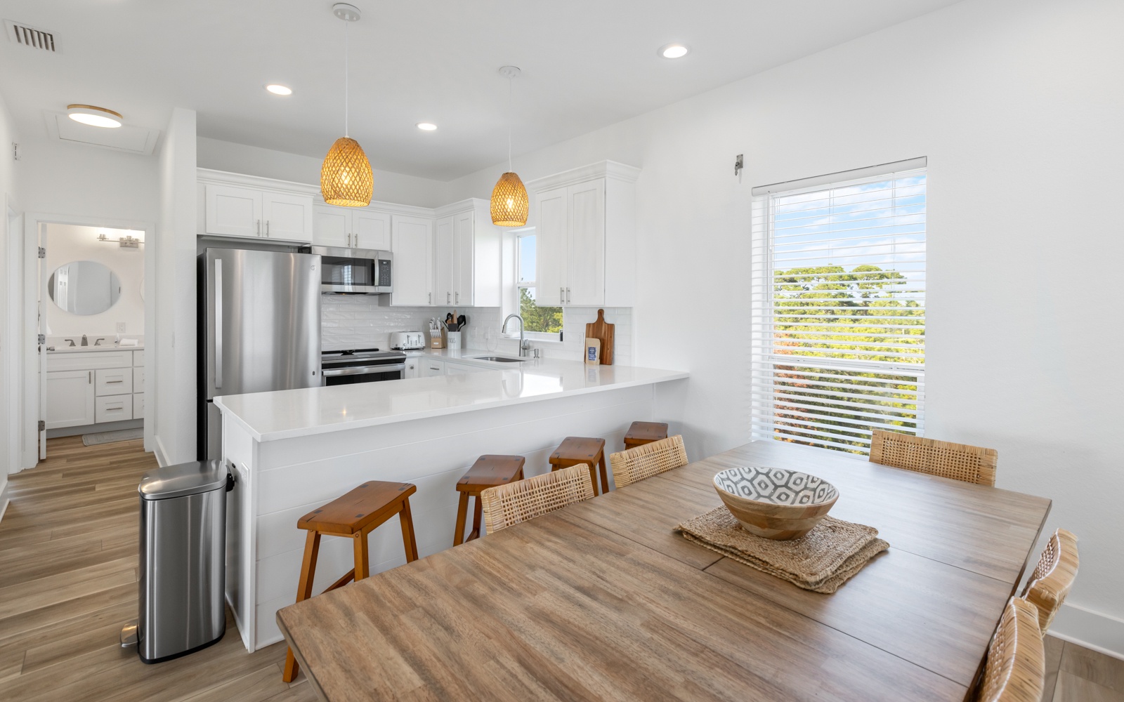 Your modern open-plan kitchen and dining space features sleek appliances, warm pendant lighting, and a welcoming table for memorable meals together.