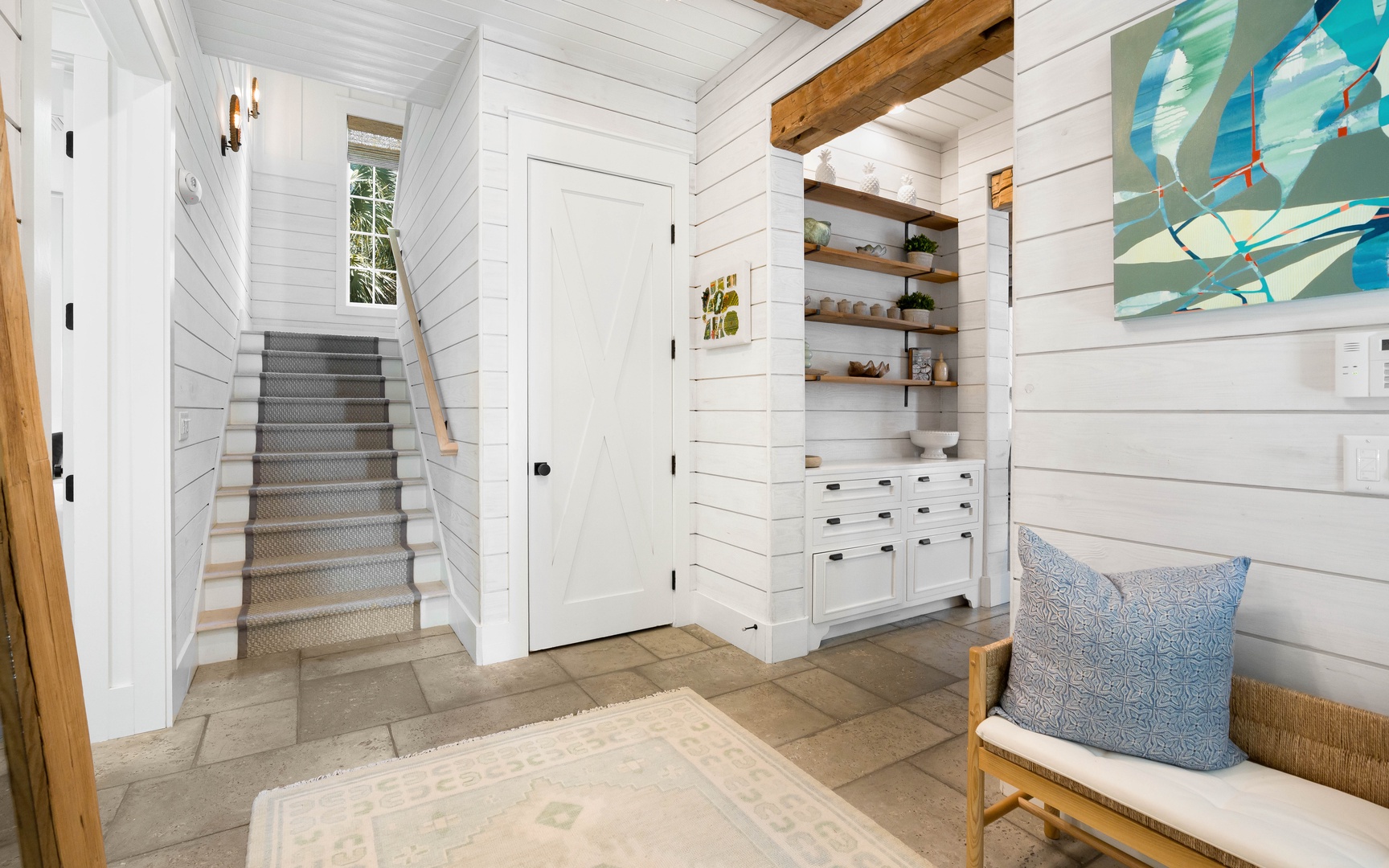 Step into your coastal retreat where shiplap walls and exposed beams create the perfect blend of comfort and charm for your getaway.