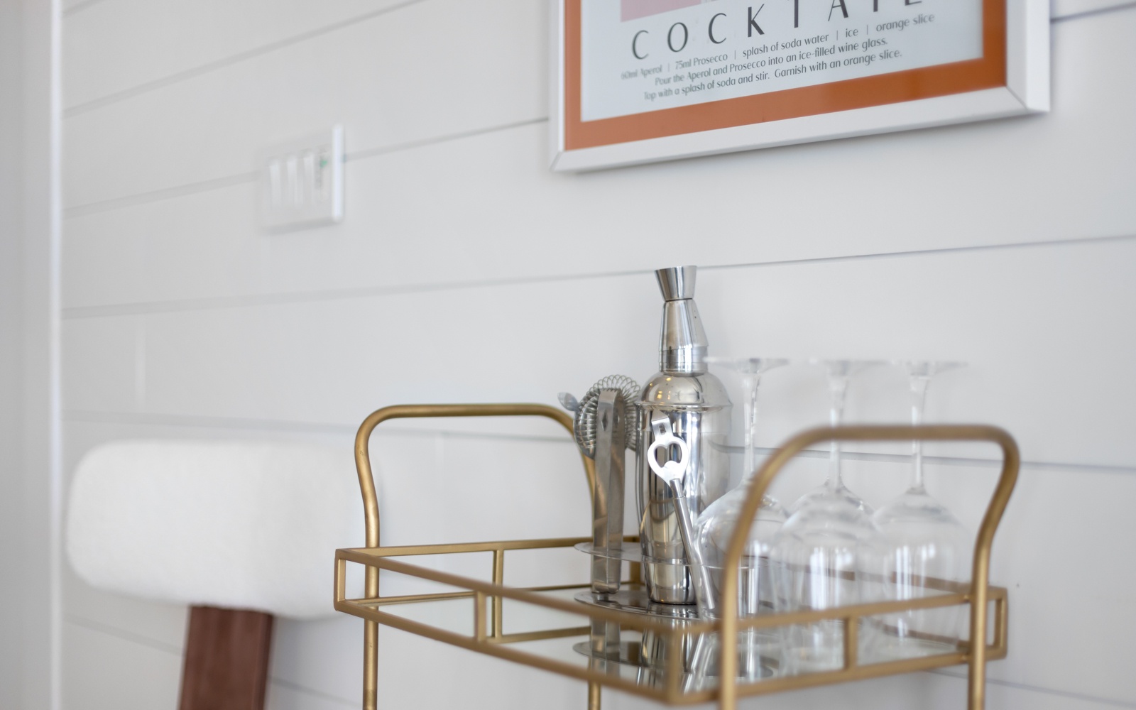 Craft cocktails await on your stylish bar cart, complete with premium glassware and cocktail shaker for memorable evenings.