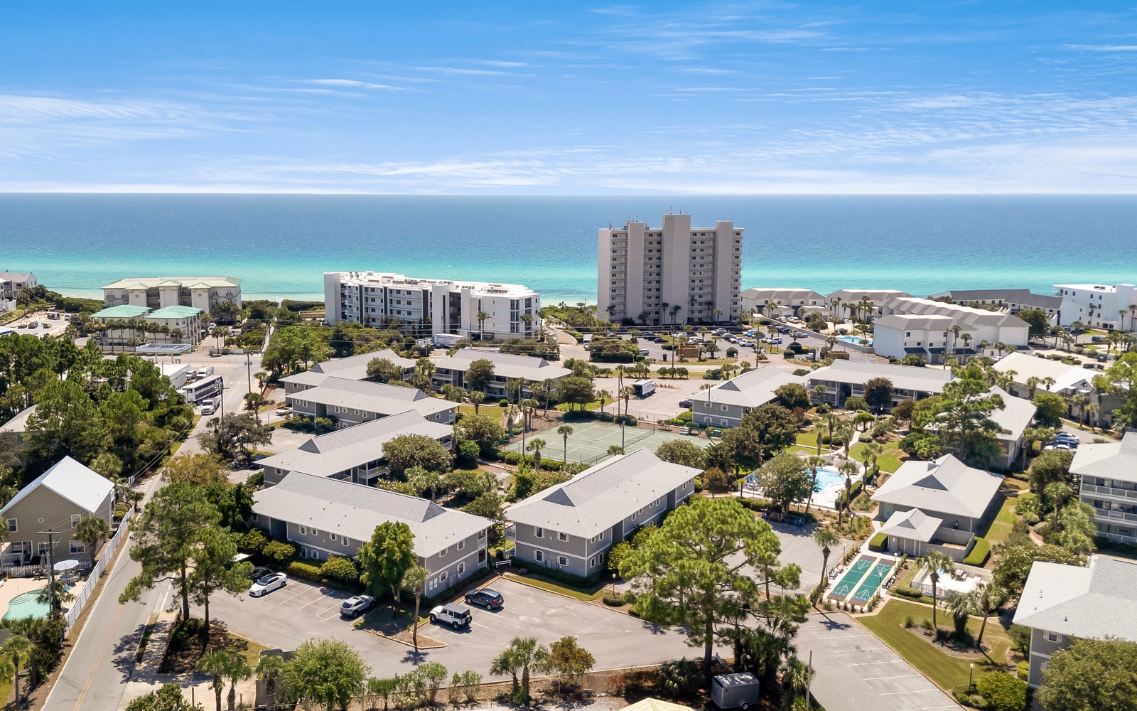 Aerial view of beachfront community with turquoise waters and white sand beaches just steps away.