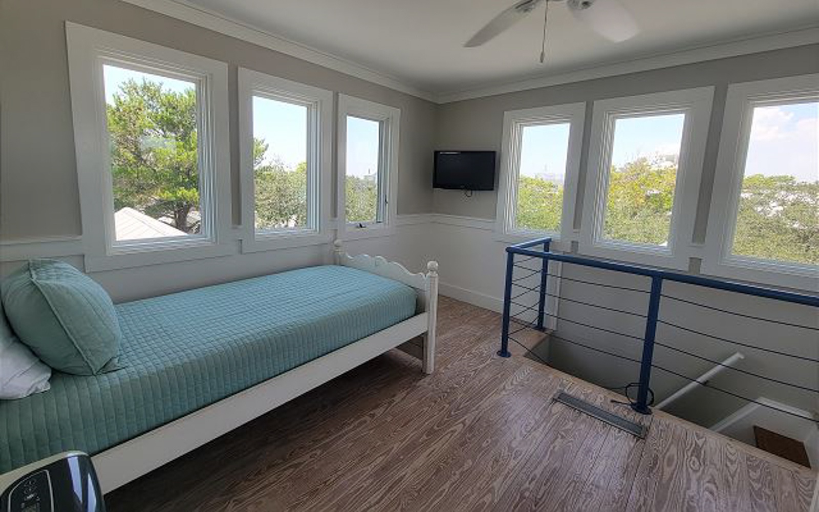 Wake up to stunning treetop views from your bright bedroom, where coastal breezes flow through multiple windows and modern comfort meets natural beauty.