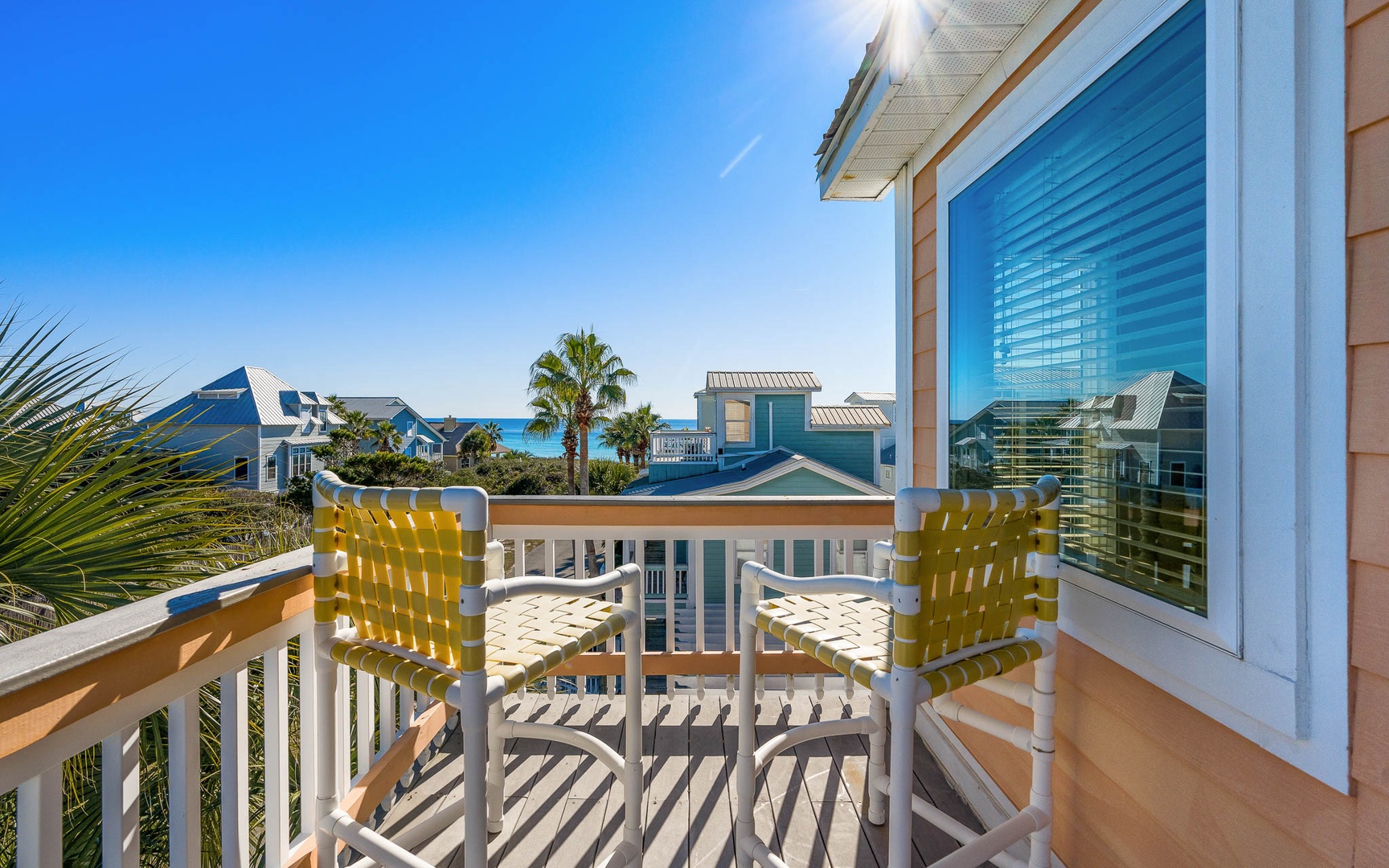 Bright yellow chairs await on your private balcony, perfect for morning coffee while soaking up coastal views and gentle ocean breezes.