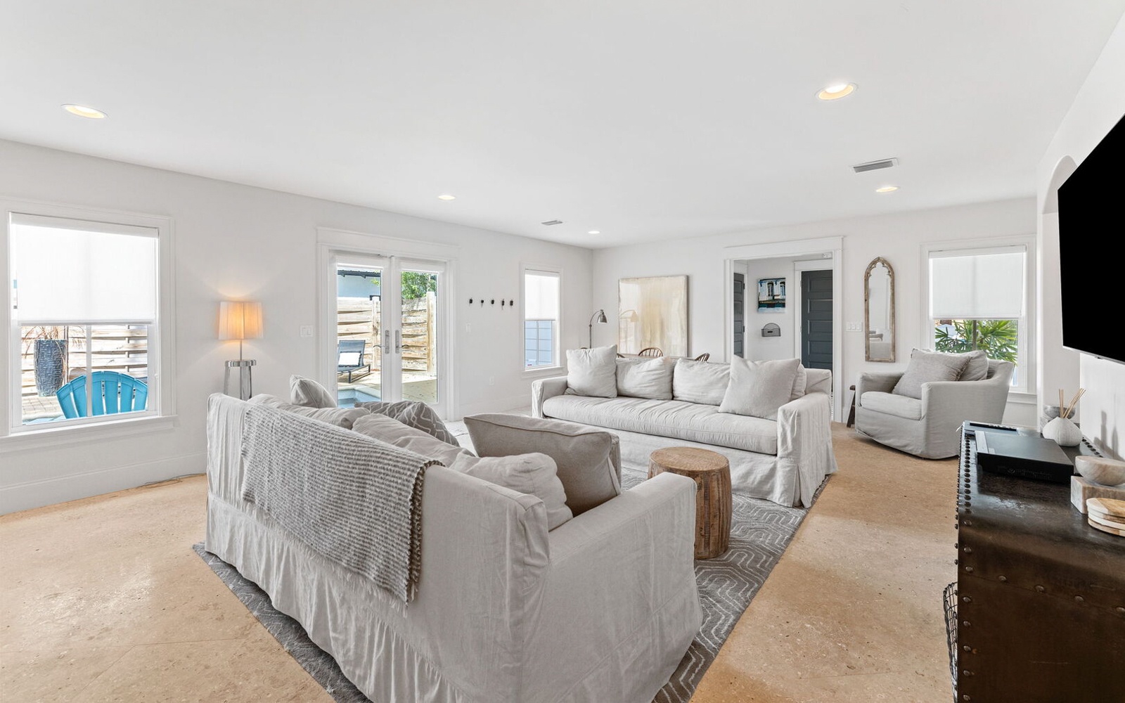 Relax in your bright, spacious living room with plush seating and coastal views through large windows.