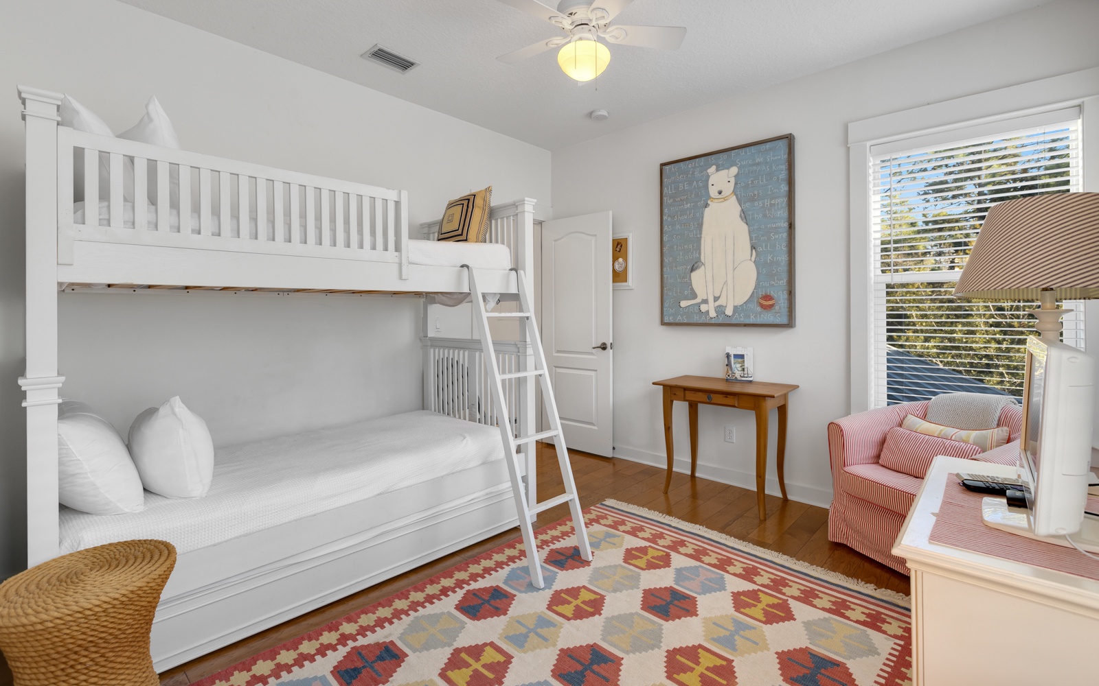 Your kids will love this charming bunk room with cozy white beds, playful artwork, and a reading nook by the window.