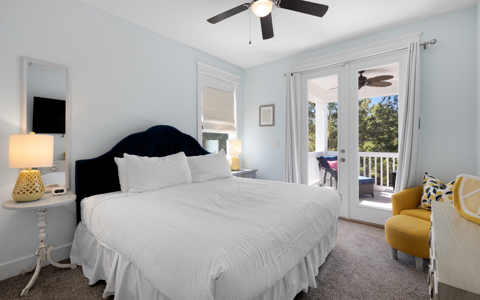 Drift off in this serene bedroom where soft blues meet crisp whites, and your private balcony opens to peaceful treetop views.