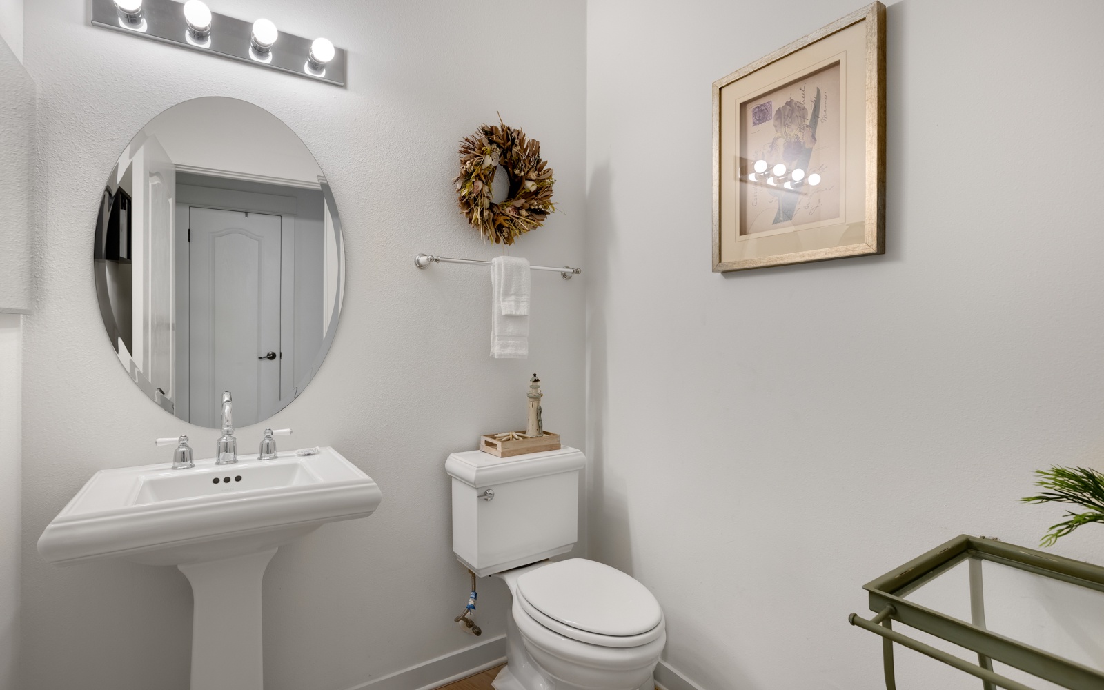 Fresh your morning routine in this thoughtfully appointed powder room, featuring elegant vanity lighting and welcoming touches.