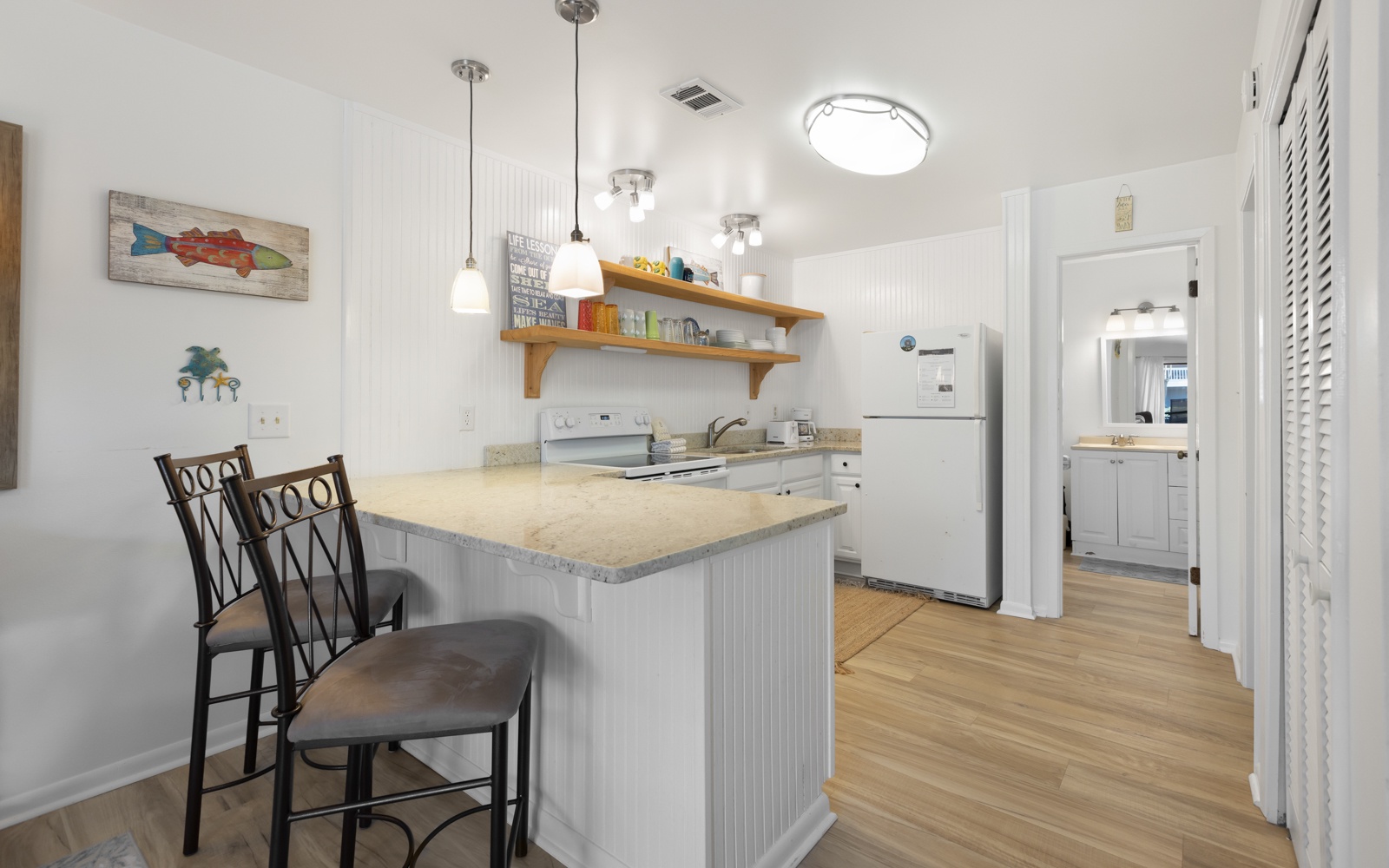 Your fully equipped kitchen invites morning coffee at the breakfast bar, with modern appliances and charming coastal touches for home-cooked meals.
