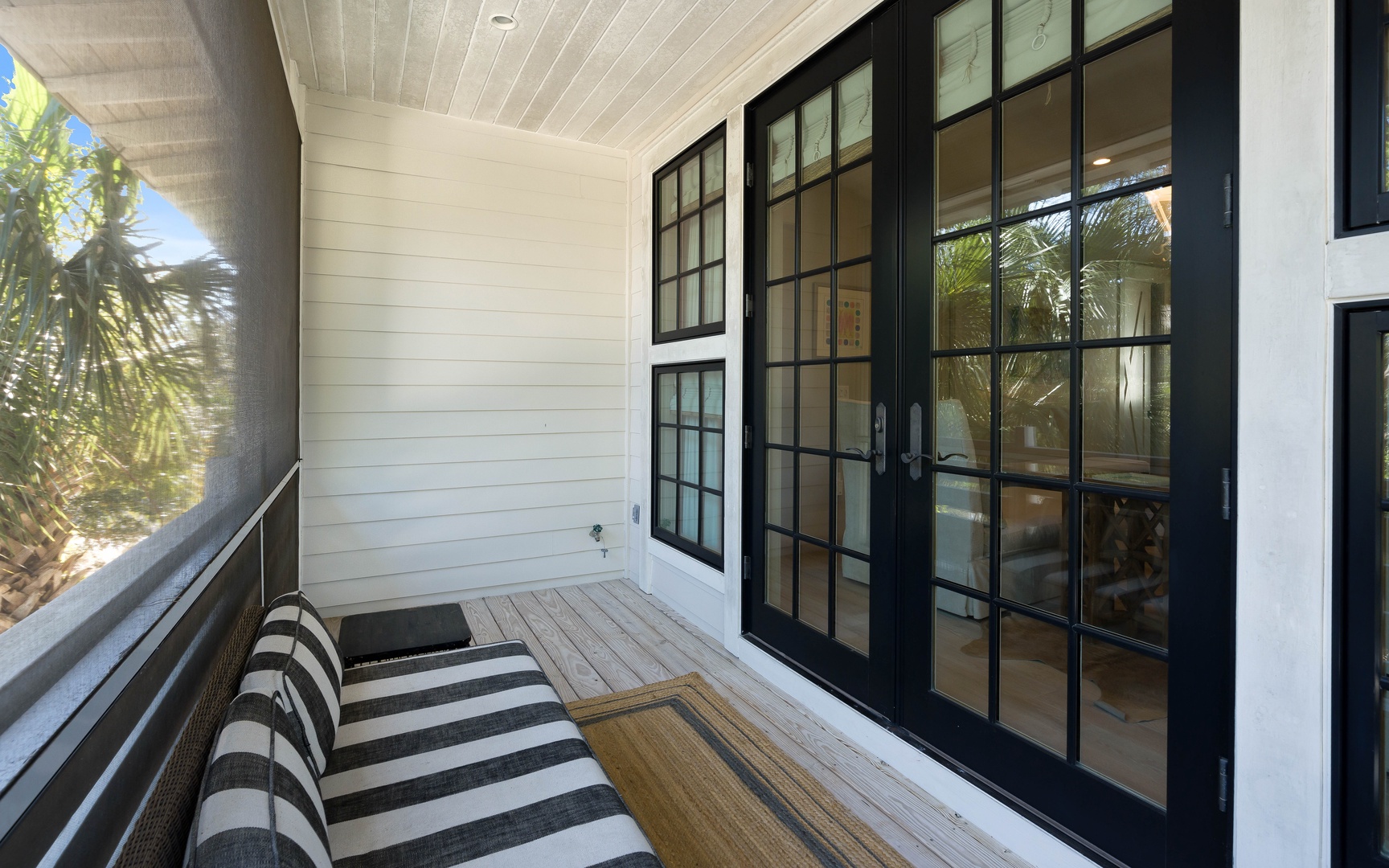 Your private balcony offers a peaceful retreat with comfortable seating and elegant French doors opening to your coastal hideaway.