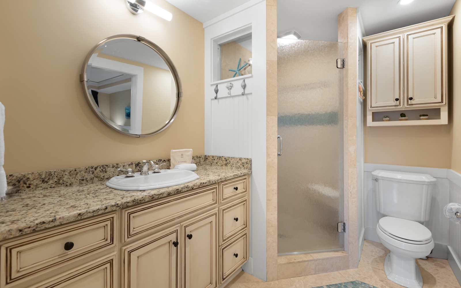 Step into your elegantly appointed bathroom featuring a spacious walk-in shower, granite vanity, and coastal touches that make getting ready feel like a spa retreat.