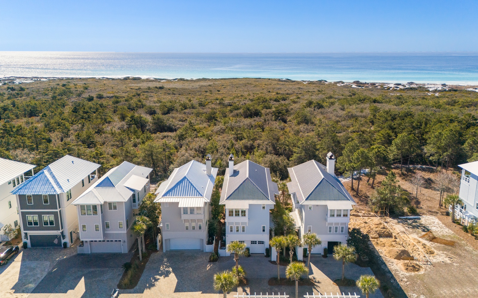 Coastal vacation homes nestled between protected dunes and pristine shoreline, offering direct beach access in a serene natural setting.