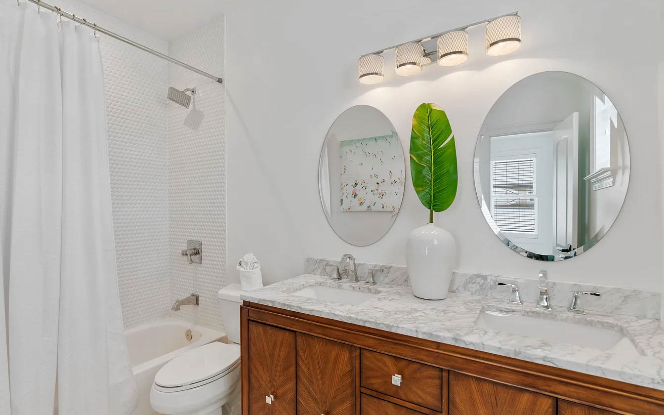 Your elegant bathroom features marble countertops, dual vanities, and a relaxing tub-shower combo for a spa-like retreat.