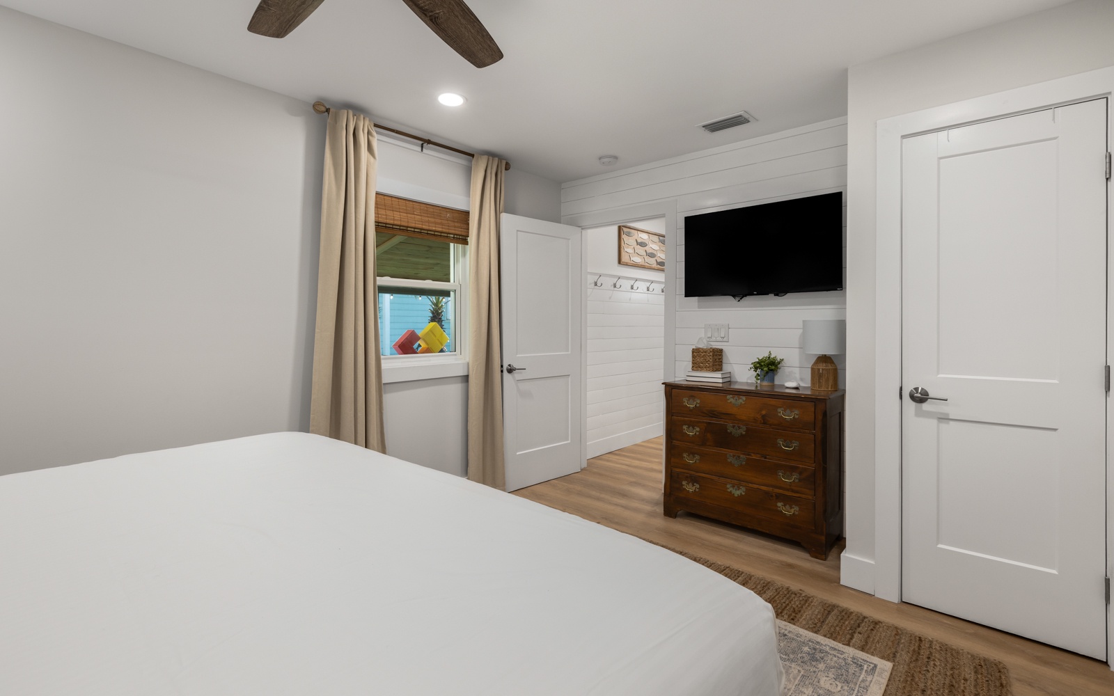 Drift off to sleep in your peaceful bedroom featuring rustic wood beams overhead, a mounted TV for evening relaxation, and warm touches throughout this inviting space.