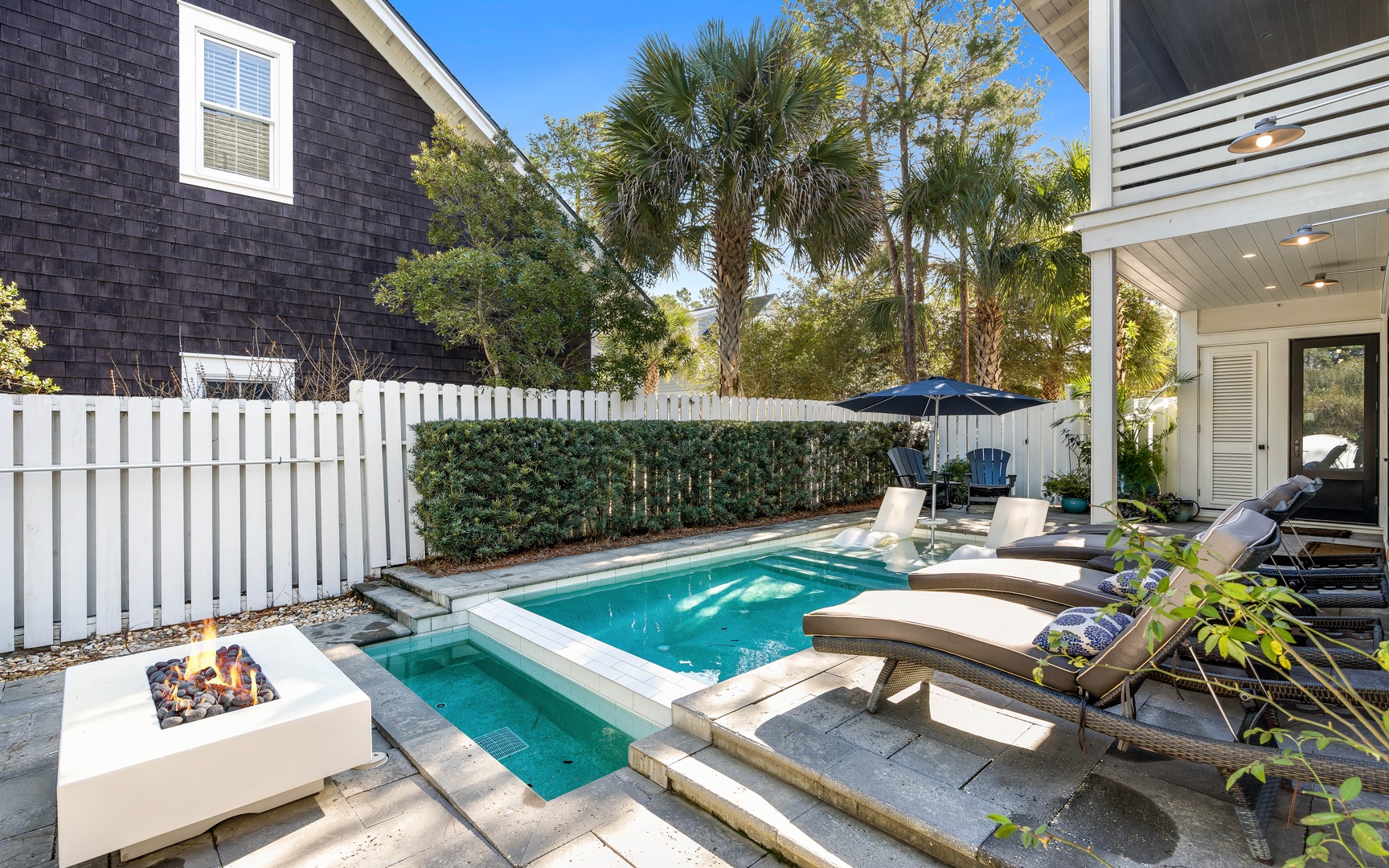 Your private pool oasis awaits with comfortable loungers, a warming fire pit, and lush tropical landscaping creating the perfect retreat.