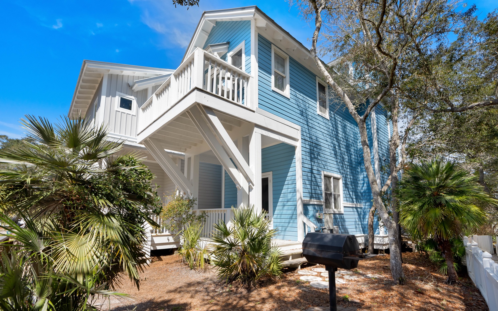 Charming coastal property with tropical landscaping and outdoor balcony, perfect for your beach getaway retreat.