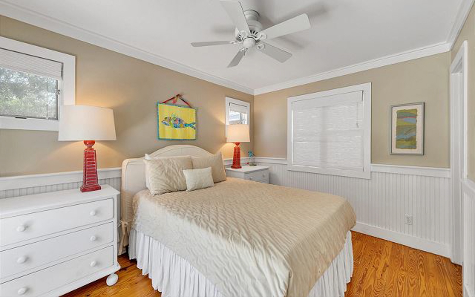 Drift off in your cozy coastal bedroom with warm natural light, ceiling fan comfort, and charming nautical touches throughout.