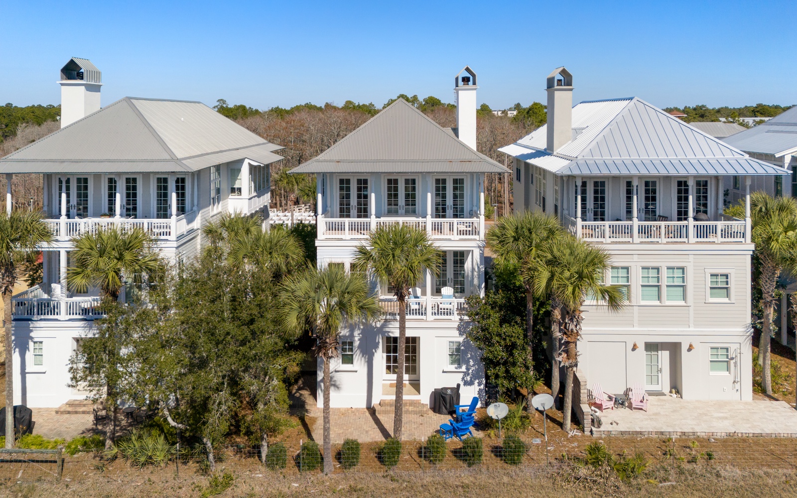 Elegant coastal townhomes with classic architecture and palm-lined grounds create a serene beachside community setting.