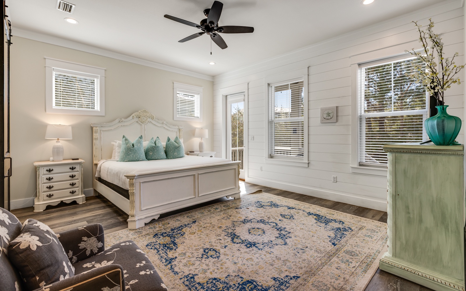Sink into your elegant master bedroom featuring soft coastal colors, crisp linens, and gentle ceiling fan breezes for perfect sleep comfort.