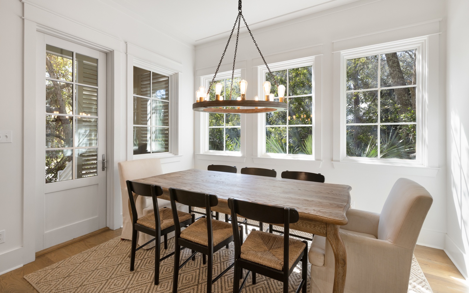 Gather around this beautiful dining table where natural light pours through large windows, creating the perfect ambiance for memorable meals together.