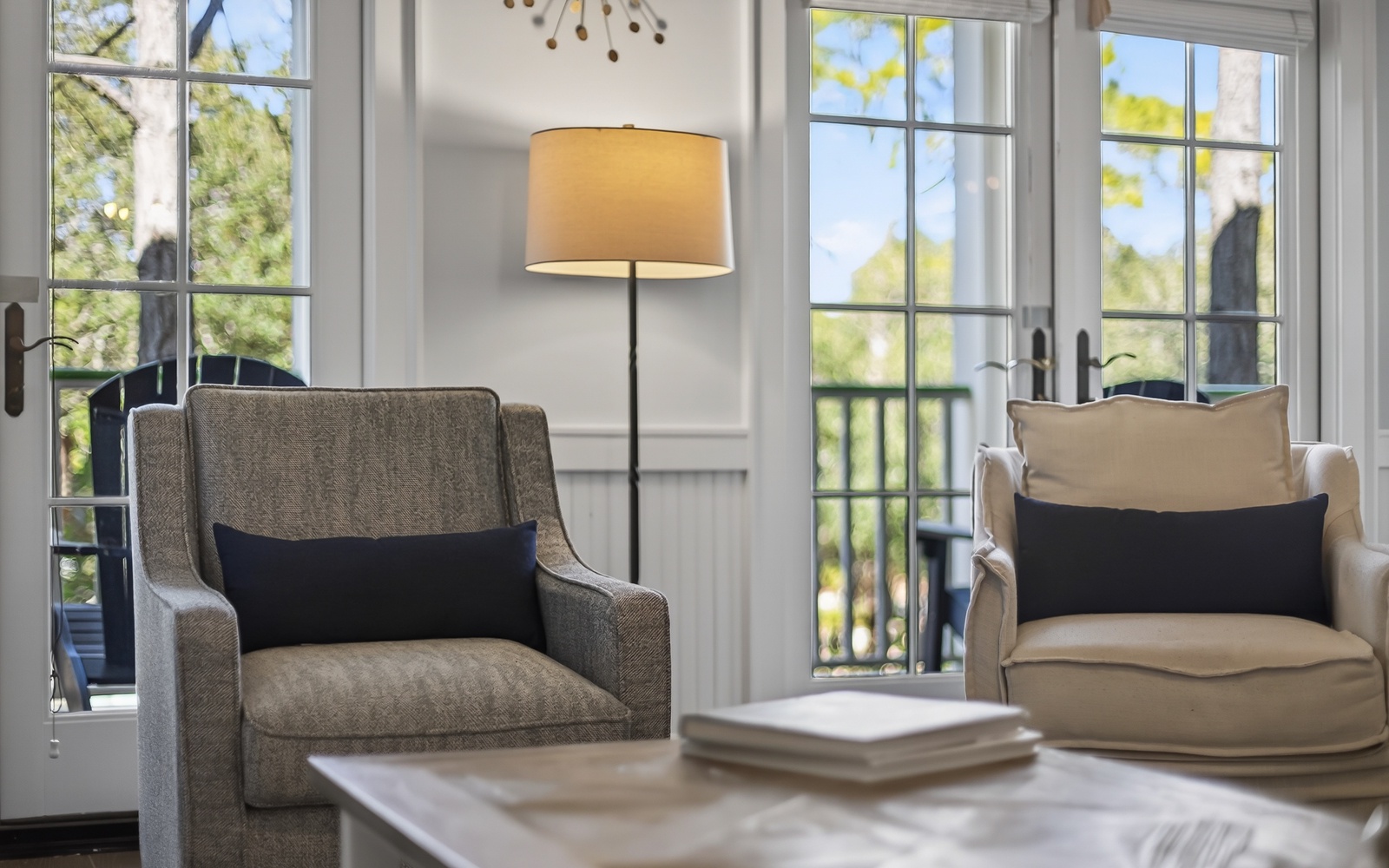 Settle into plush armchairs by sun-filled windows where natural light dances through elegant frames, creating your perfect reading nook.