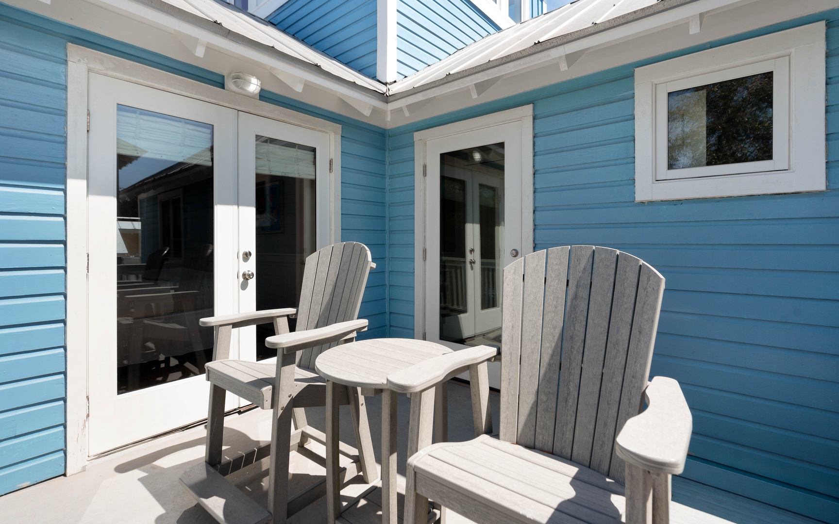 Your charming private patio invites relaxation with comfortable Adirondack chairs and a sunny courtyard setting.