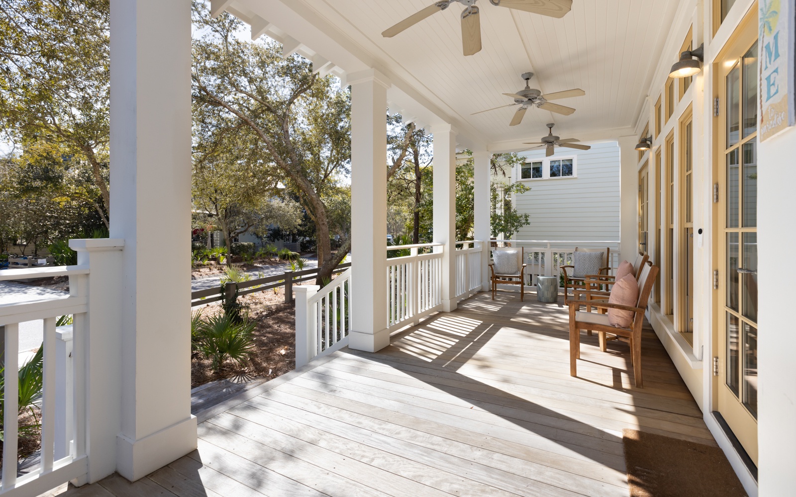 Relax on your private covered porch with comfortable seating, gentle ceiling fans, and peaceful garden views creating the perfect spot for morning coffee.
