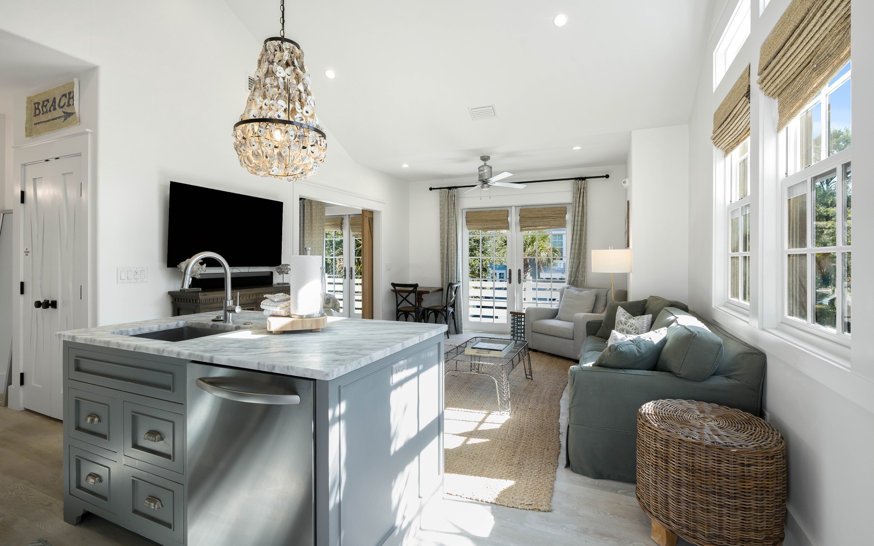 Your bright, airy living space features elegant coastal design with a stunning chandelier and seamless kitchen-to-living flow for perfect entertaining.