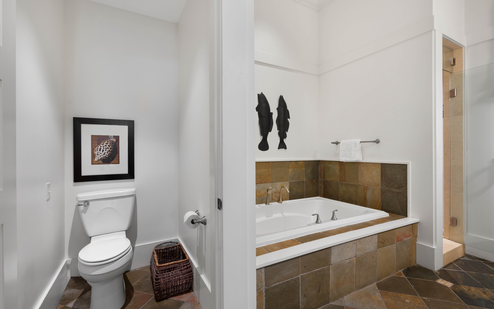 Unwind in your private spa-like bathroom with a deep soaking tub surrounded by warm stone tiles and elegant fixtures.