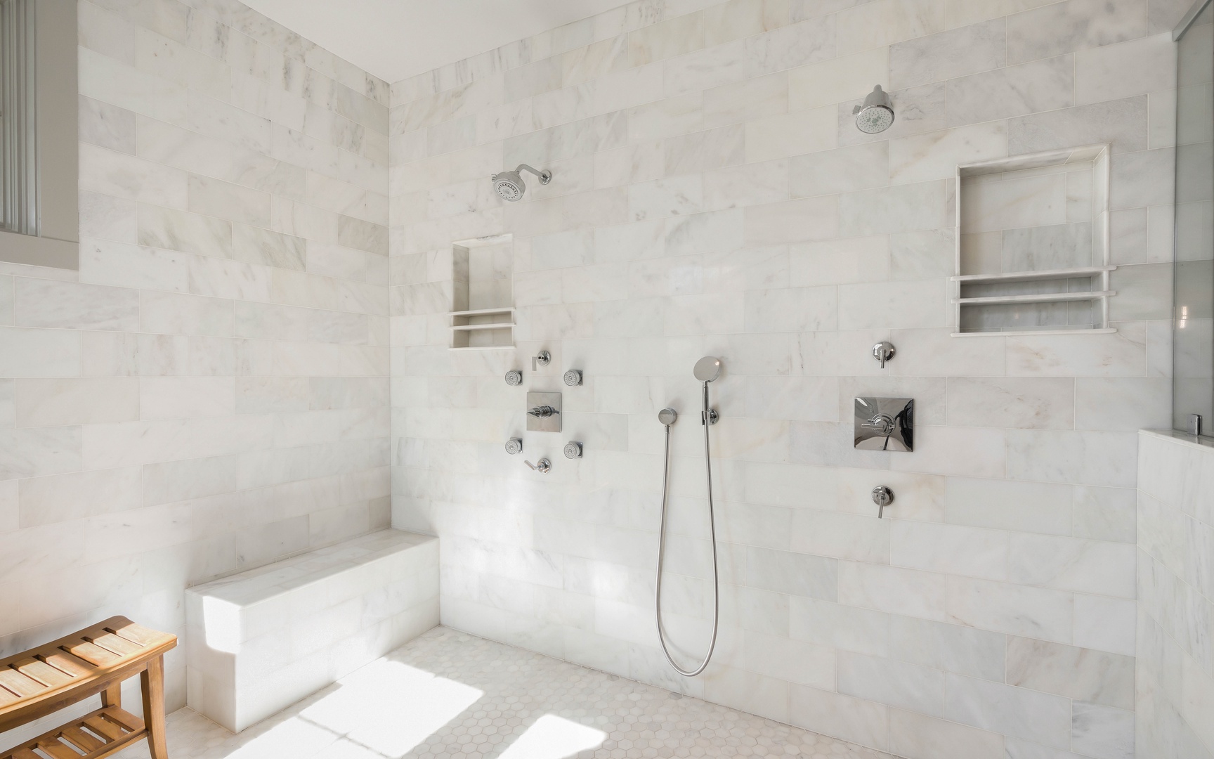 Indulge in your private spa-like marble bathroom with dual rainfall showers and body jets for the ultimate relaxation experience.