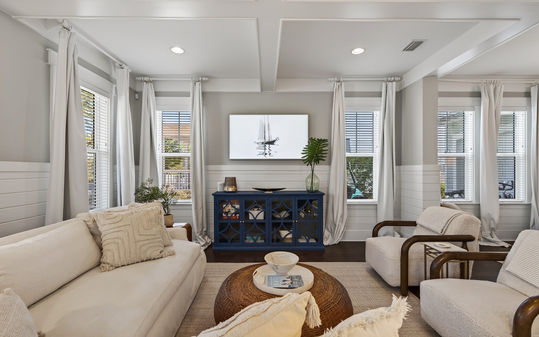 Unwind in your bright, coastal-inspired living space with plush seating and peaceful neighborhood views through every window.
