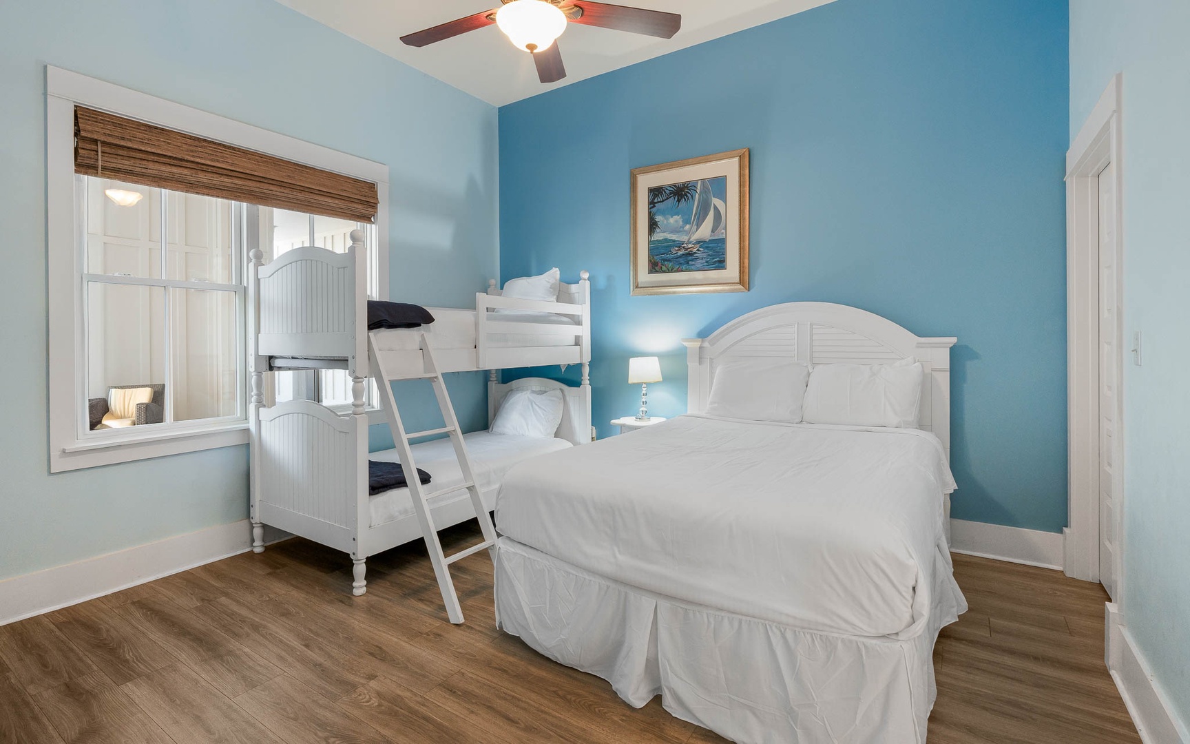 Relax in your coastal-themed bedroom with comfortable beds and soothing blue walls that create a peaceful seaside retreat.