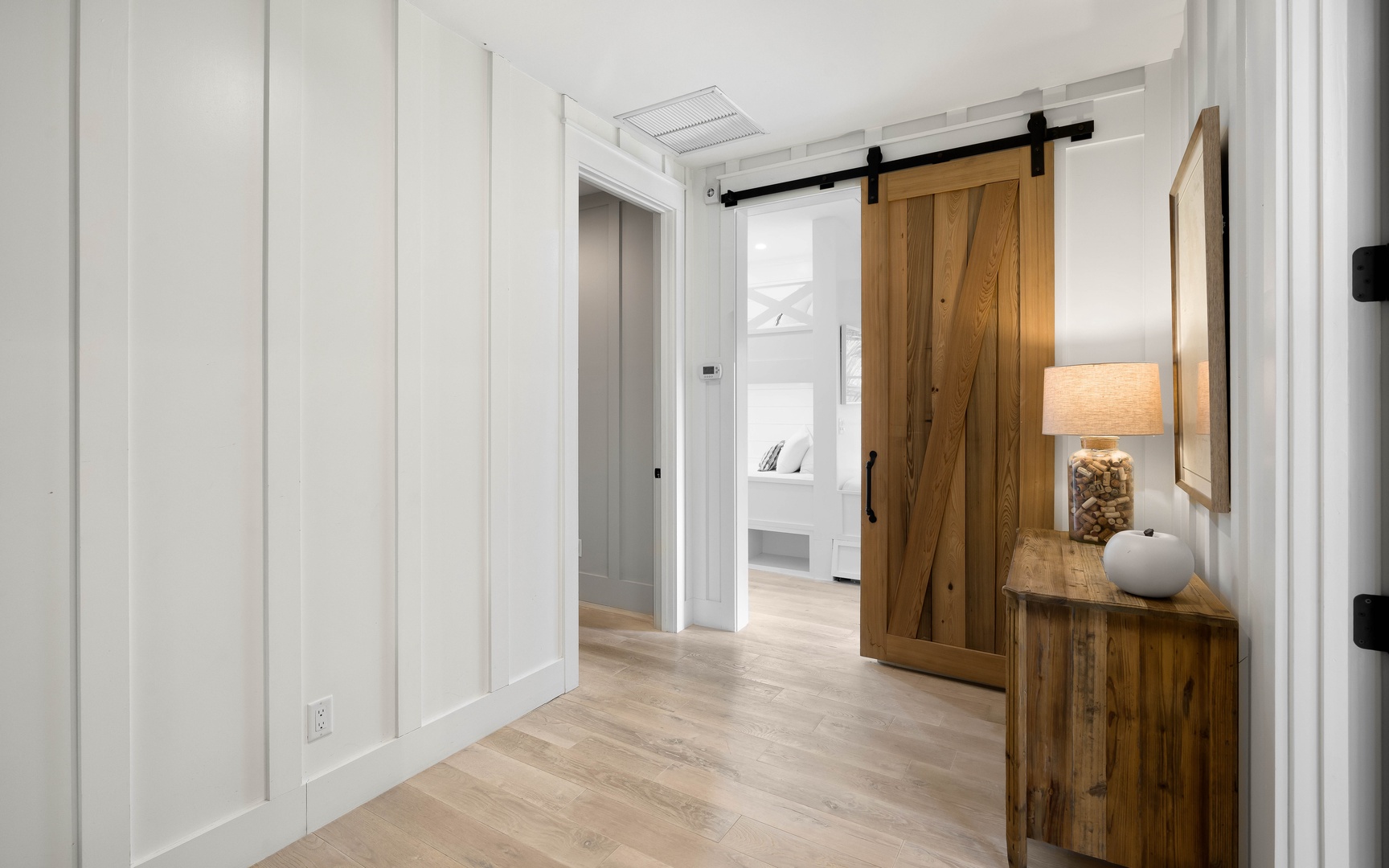 Step into your stylish hallway where rustic barn doors and coastal furnishings create a warm welcome to your peaceful retreat.