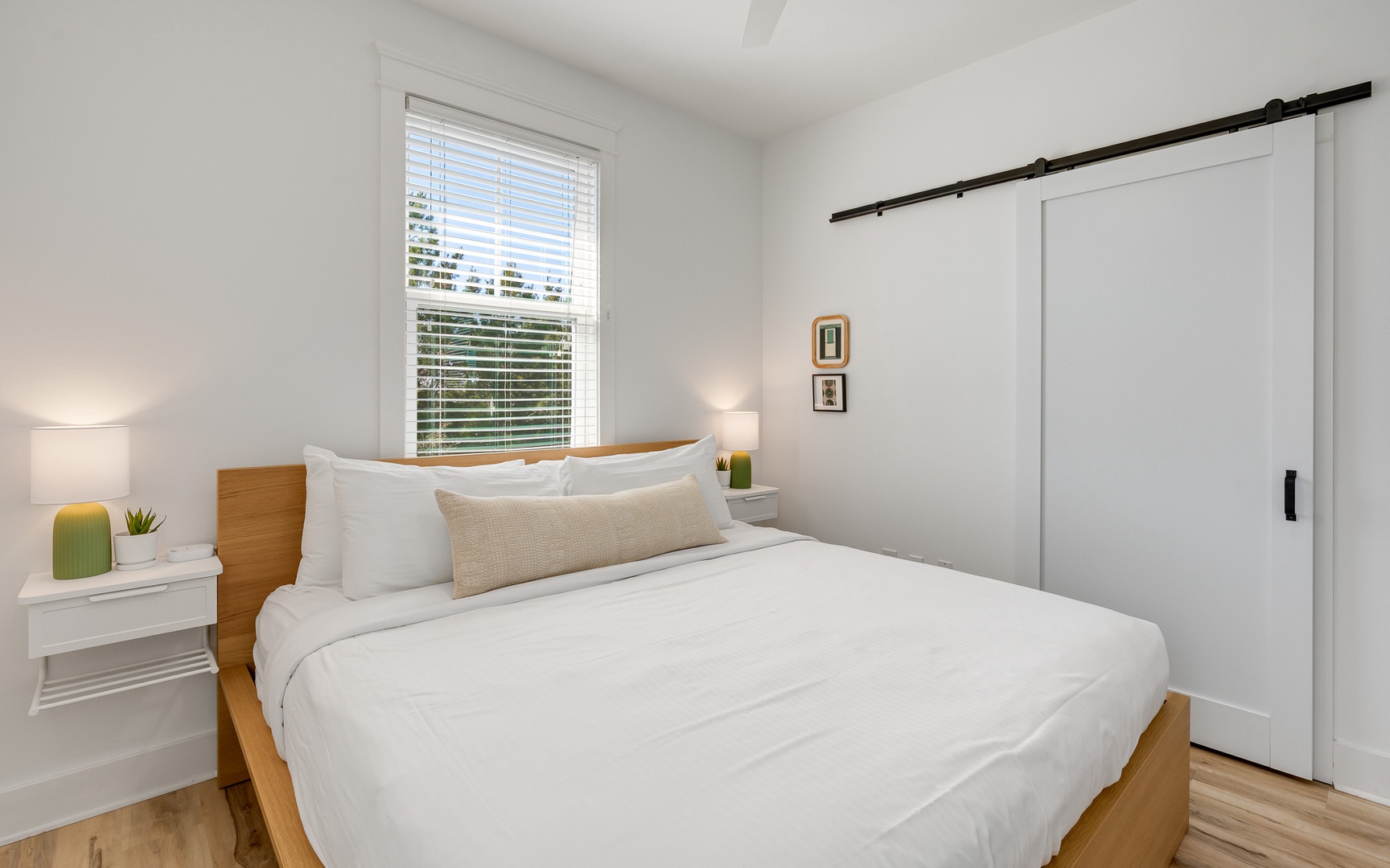 Wake up refreshed in your serene bedroom featuring crisp white linens and natural light streaming through your window.