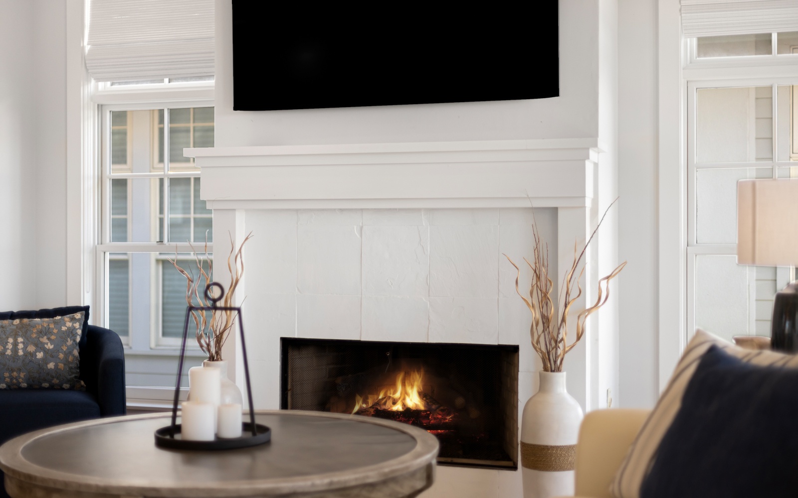 Cozy up in your elegant living room where crackling flames warm the space while you relax on plush seating.