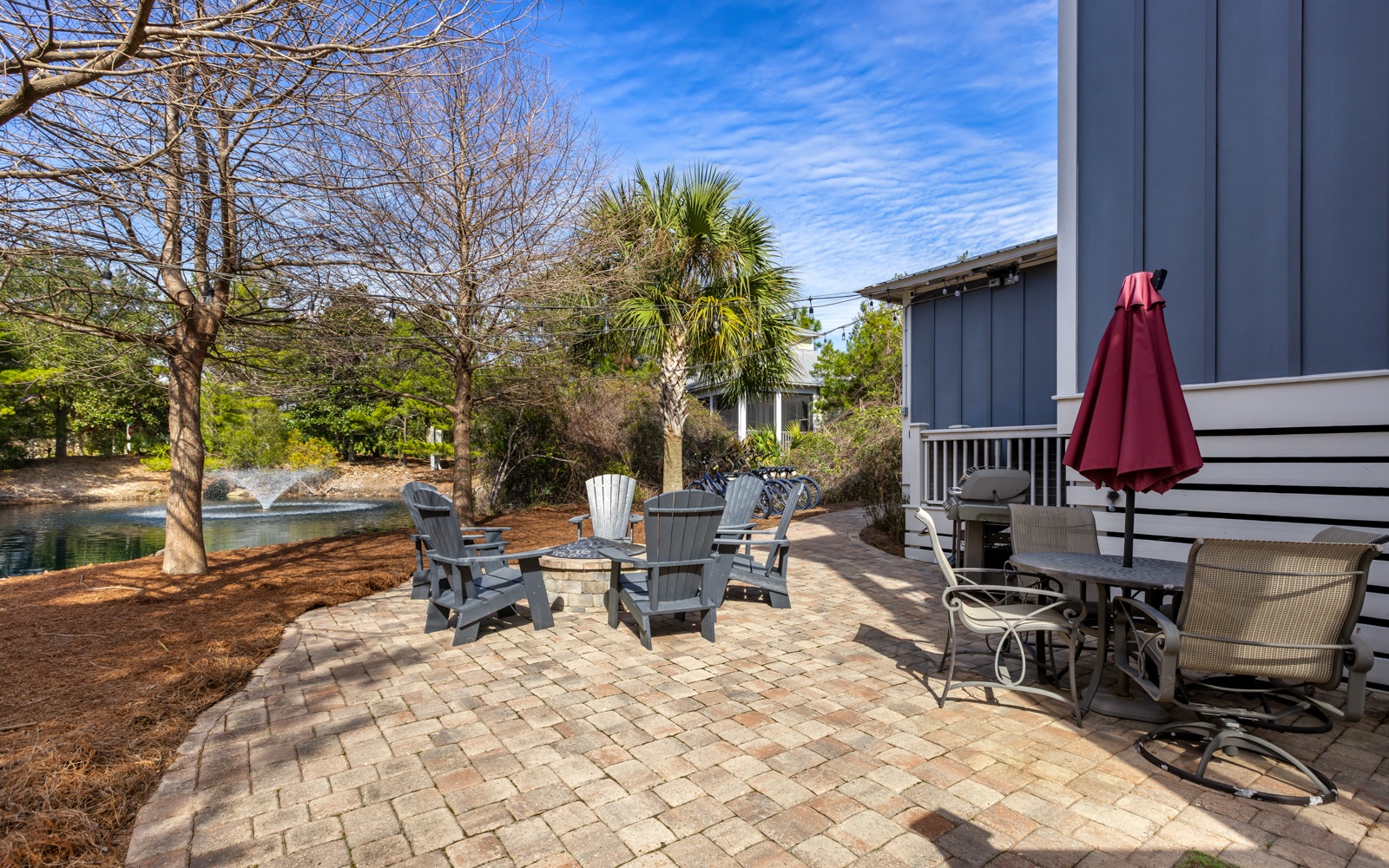Relax on your private brick patio with comfortable seating, surrounded by lush landscaping and peaceful water views.