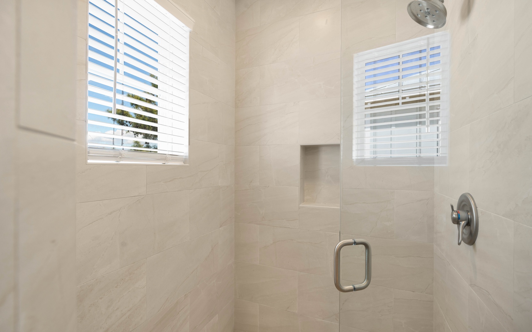 Step into your private shower sanctuary with elegant marble-style tiles and rainfall showerhead for a refreshing morning start.