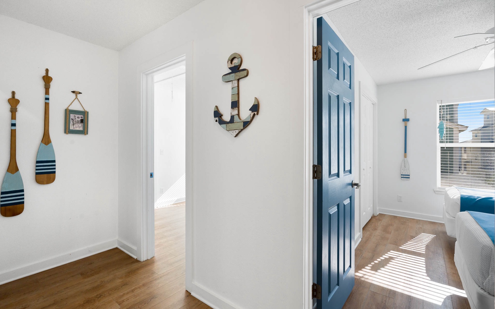 Step into your coastal haven where nautical charm meets modern comfort—sun-dappled floors and cheerful blue accents create the perfect seaside escape.